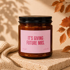 Amber jar candle with pink label reading "IT'S GIVING FUTURE MRS."