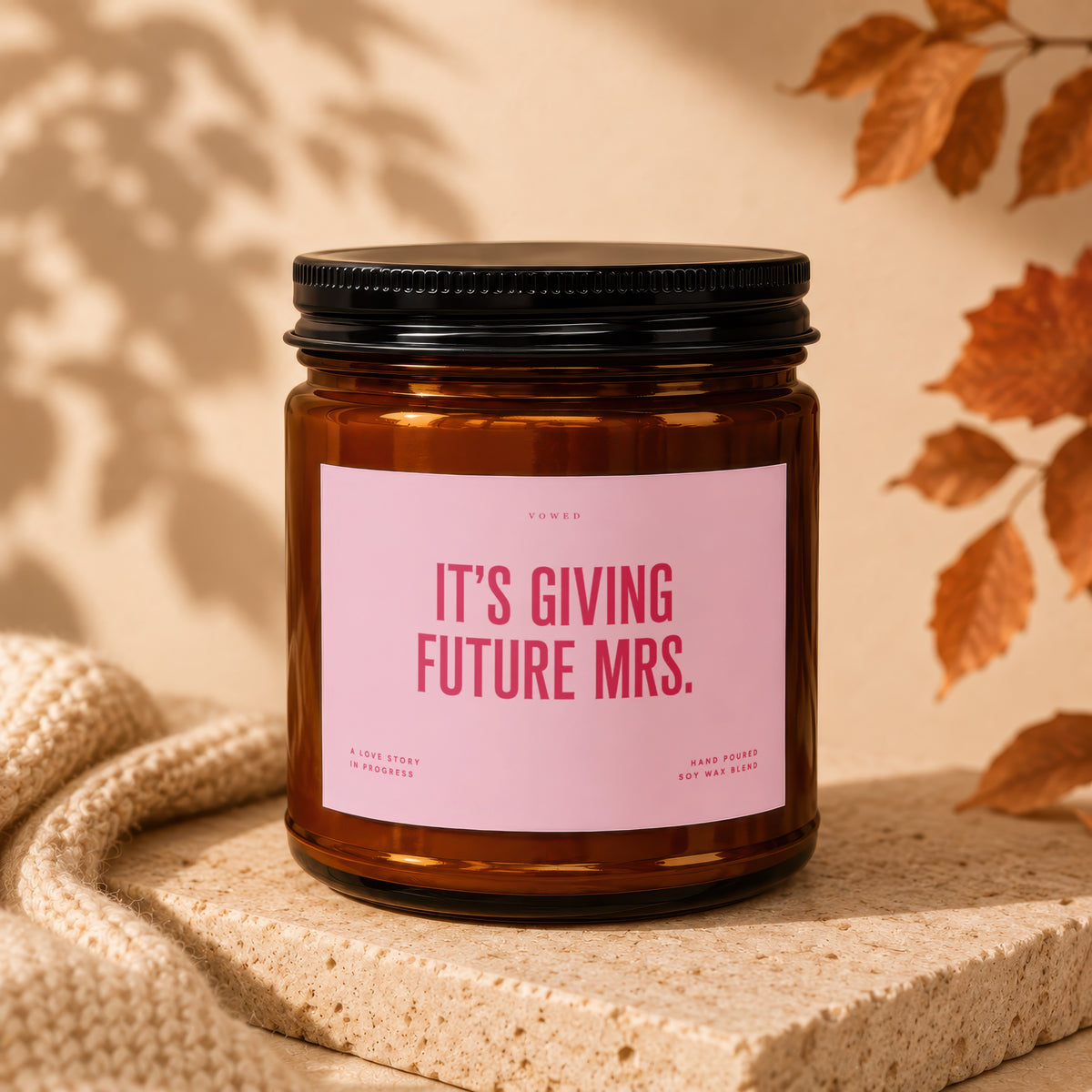 Amber jar candle with pink label reading "IT'S GIVING FUTURE MRS."