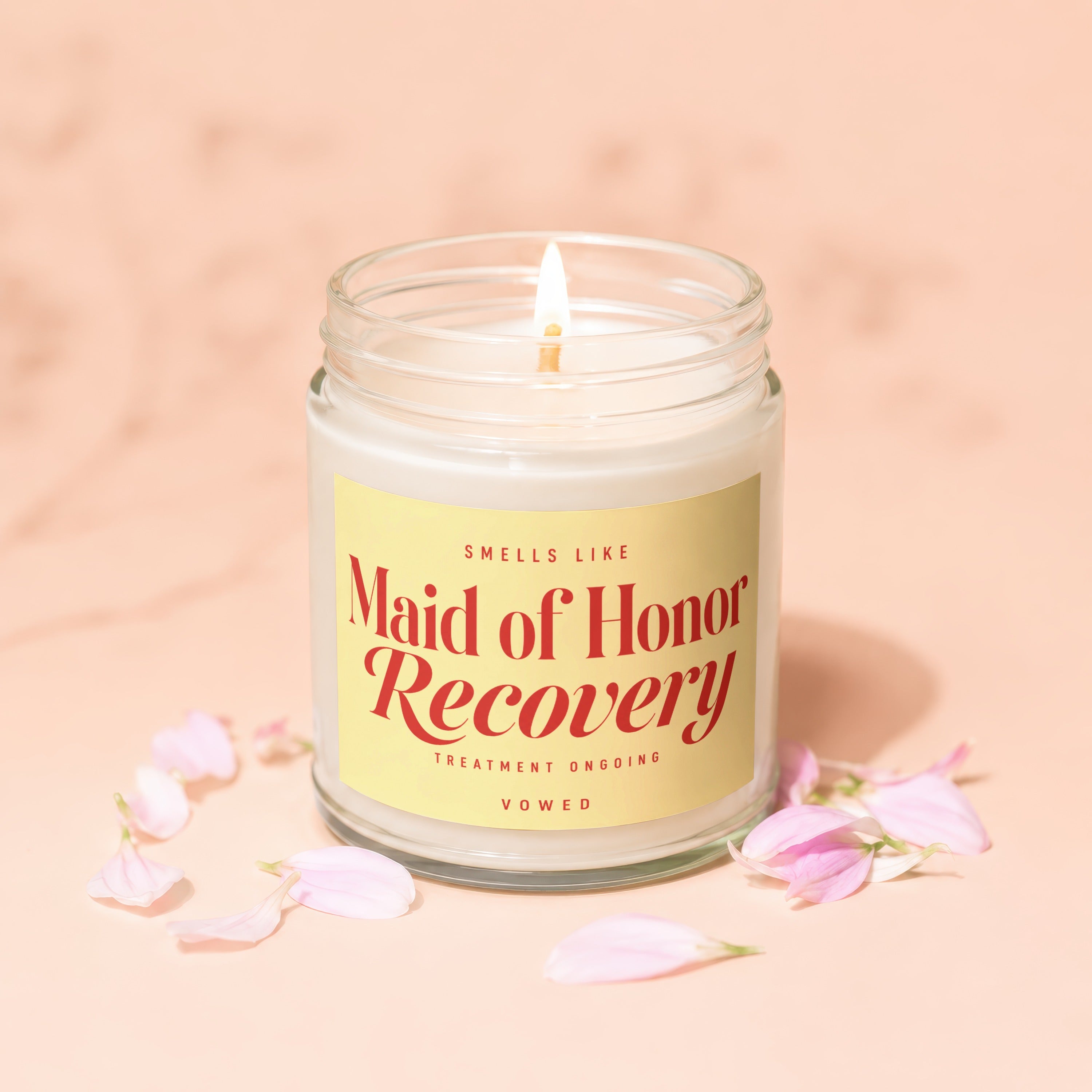 Candle with yellow label that reads "SMELLS LIKE Maid of Honor Recovery TREATMENT ONGOING VOWED".