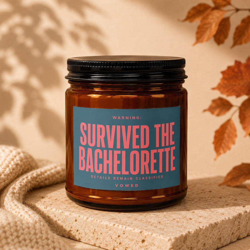 Amber glass candle with label reading "WARNING: SURVIVED THE BACHELORETTE DETAILS REMAIN CLASSIFIED VOWED".