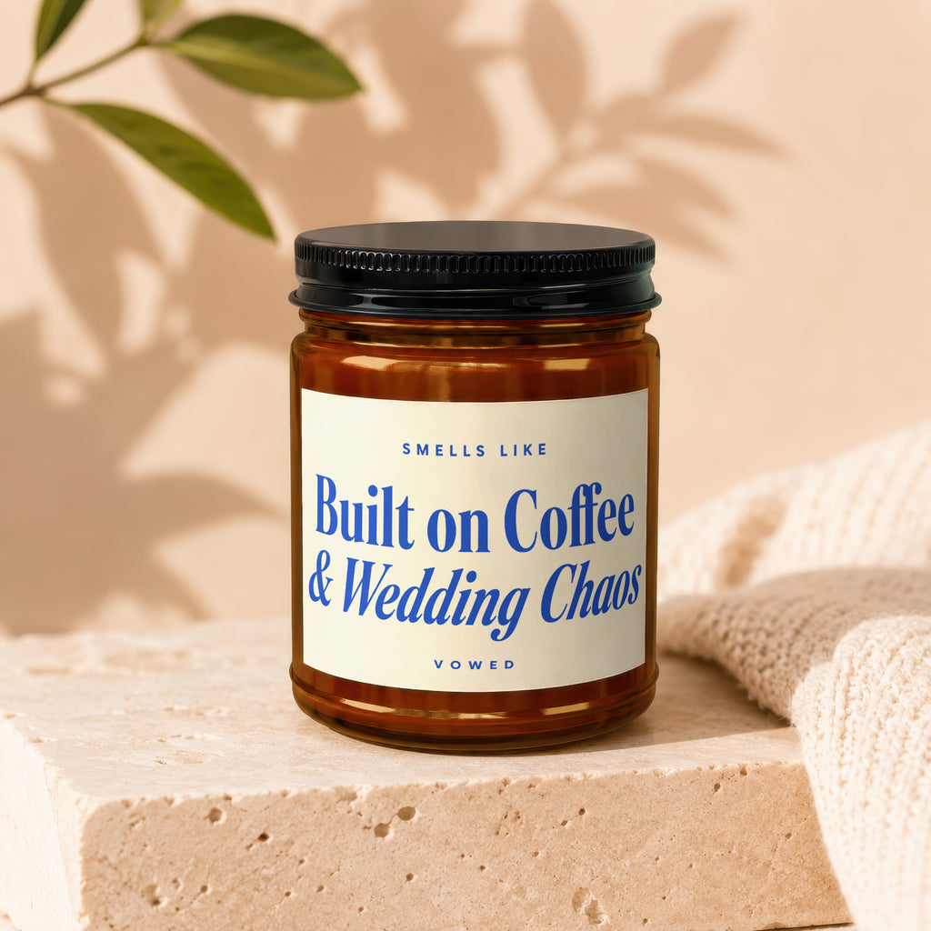 Amber candle with blue text reading "Smells like Built on Coffee & Wedding Chaos"