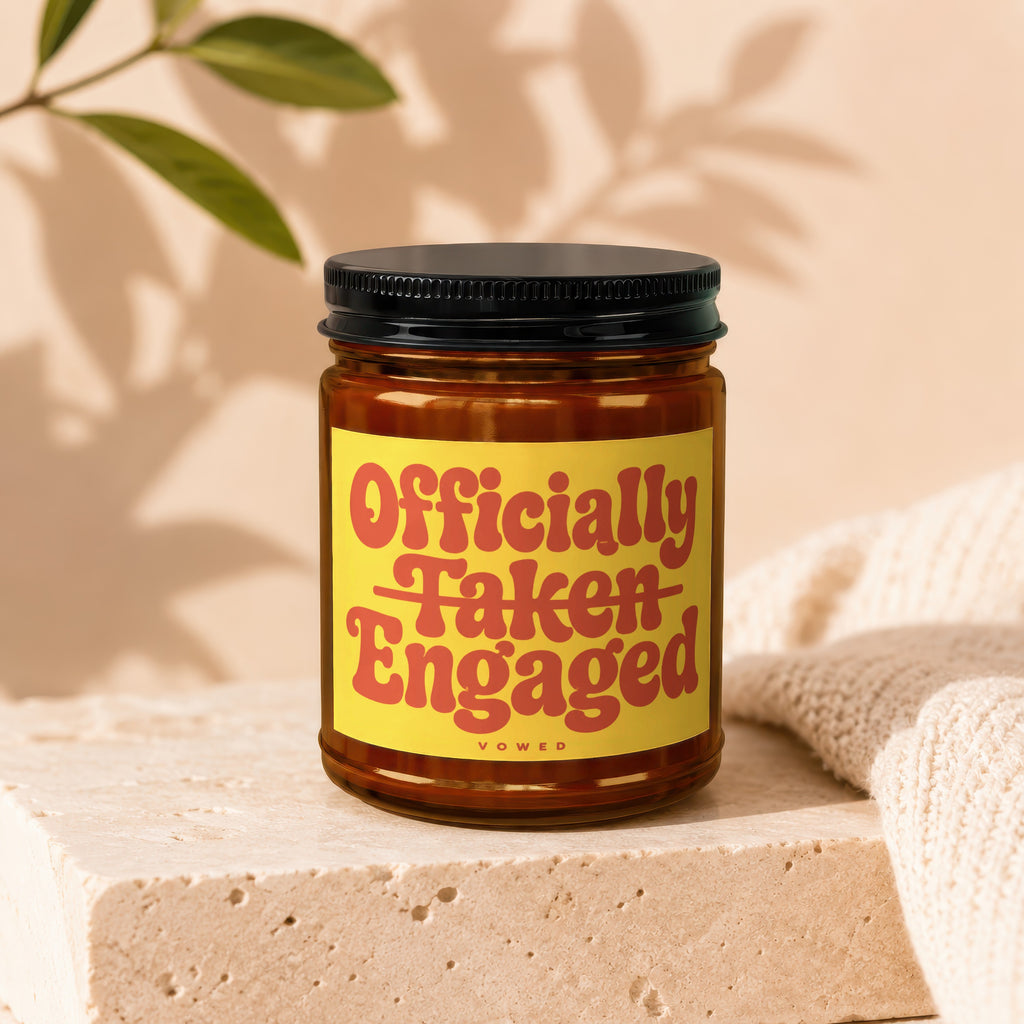 Amber jar candle with 'Officially Taken Engaged' text and 'Vowed' below.
