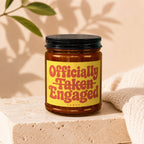 Amber jar candle with 'Officially Taken Engaged' text and 'Vowed' below.