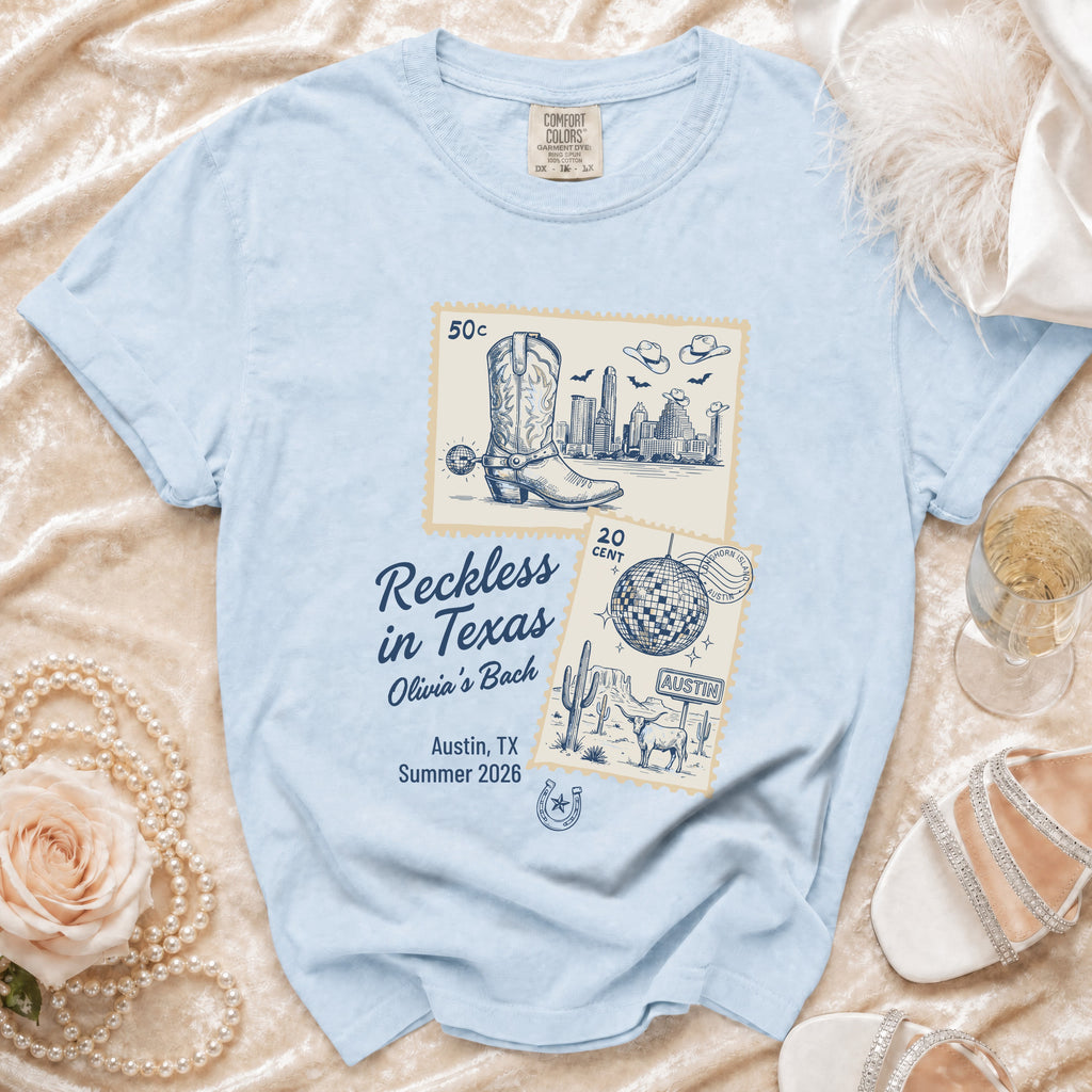 Light blue t-shirt with "Reckless in Texas Olivia's Bach" graphic.