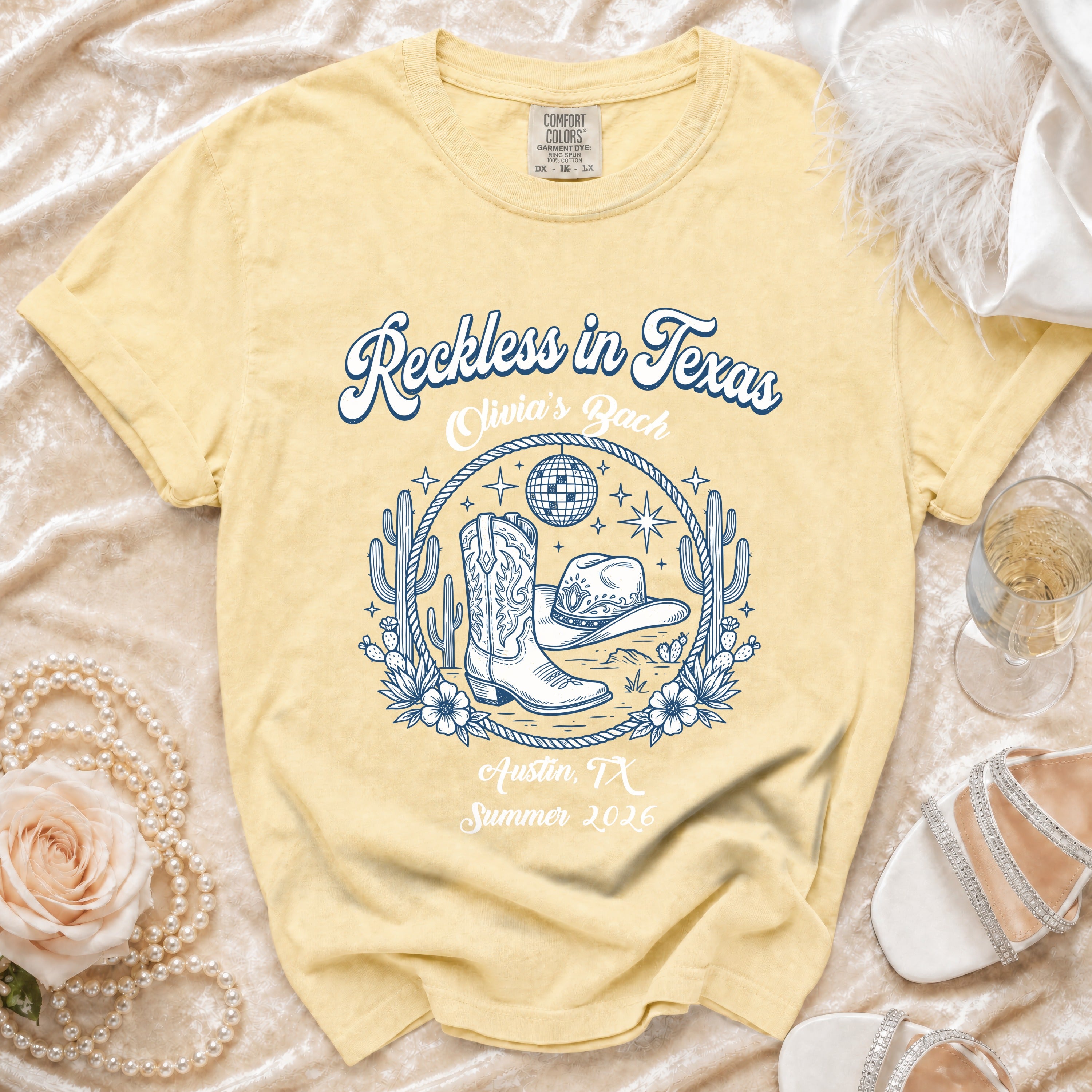 Yellow t-shirt with "Reckless in Texas, Olivia's Bach, Austin, TX, Summer 2026" text and western graphics.