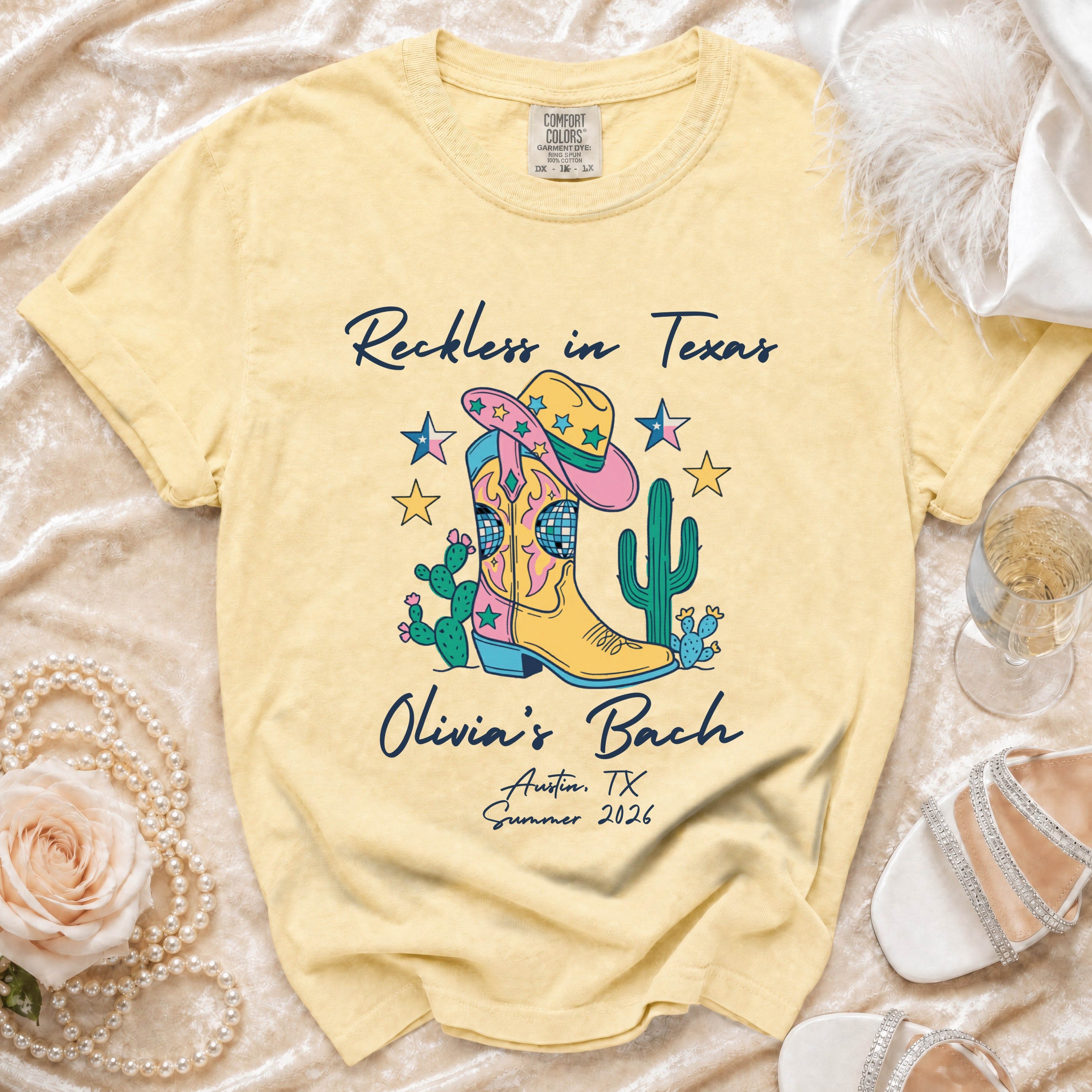 Yellow t-shirt with "Reckless in Texas Olivia's Bach Austin, TX Summer 2026" and cowboy boot graphic.