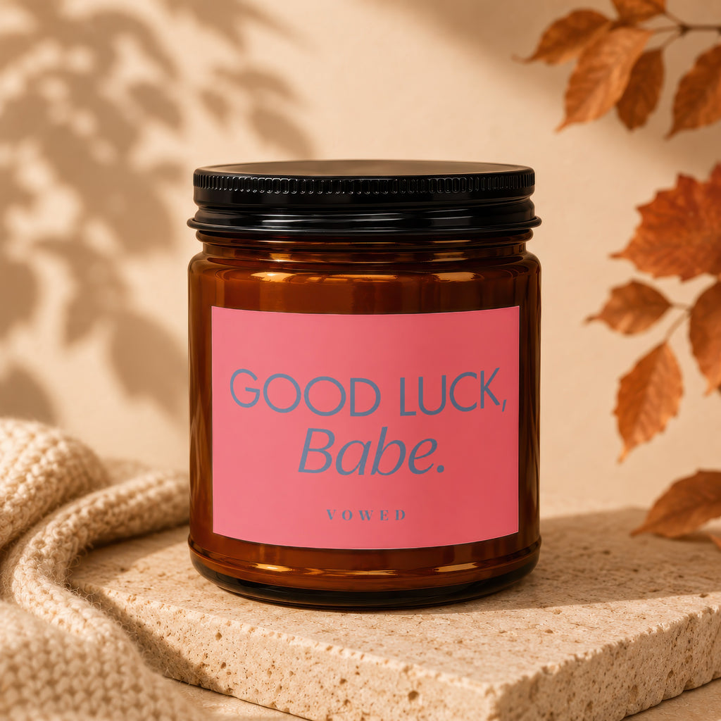 Amber candle in glass jar with pink label reading "GOOD LUCK, Babe."