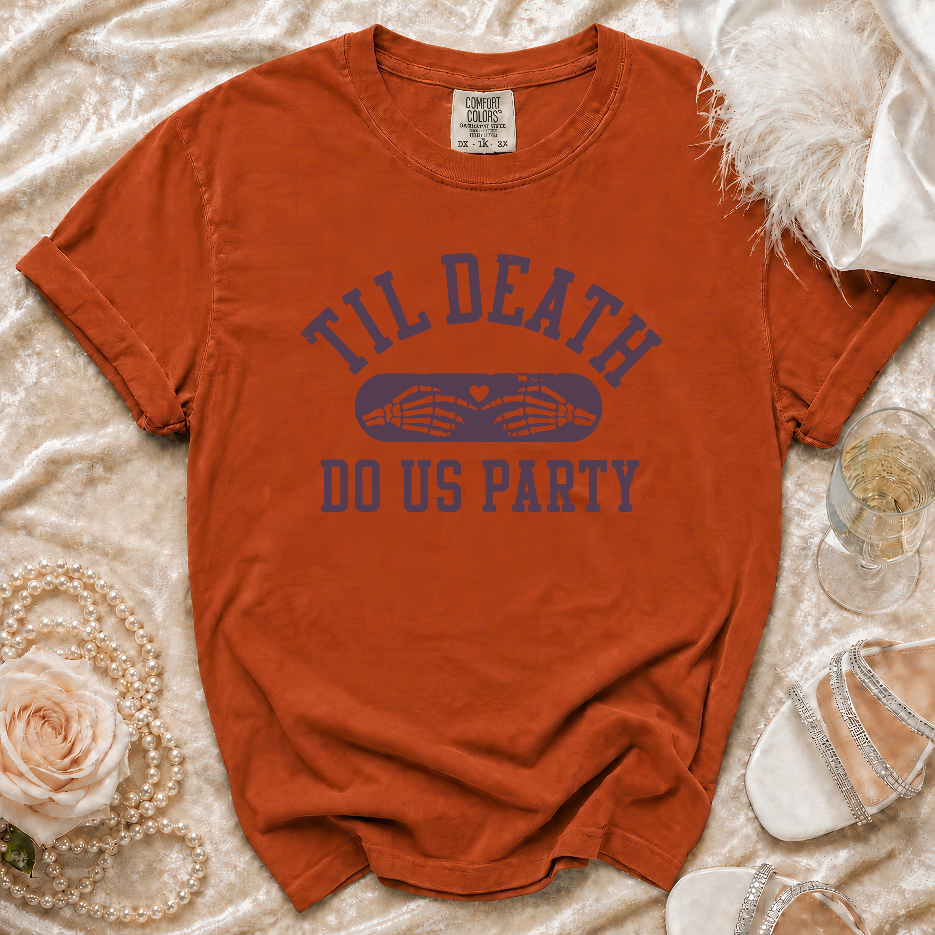 Orange t-shirt with "Til Death Do Us Party" text and skeleton hands graphic.