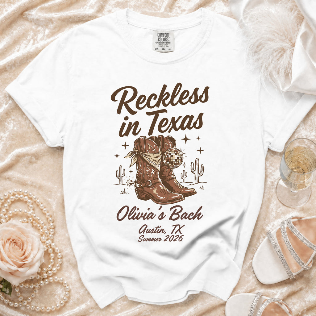 White t-shirt with "Reckless in Texas" and "Olivia's Bach Austin, TX Summer 2026".
