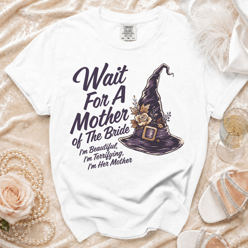 White t-shirt with purple text and witch hat graphic: "Wait For A Mother of The Bride"