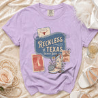 Purple Comfort Colors t-shirt with "Reckless in Texas" and disco cowgirl graphic.