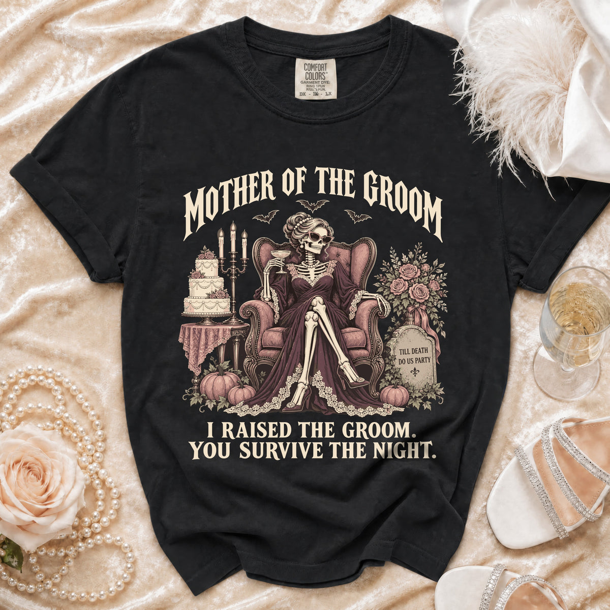 Black t-shirt with "Mother of the Groom, I Raised the Groom. You Survive the Night." text and skeleton graphic.