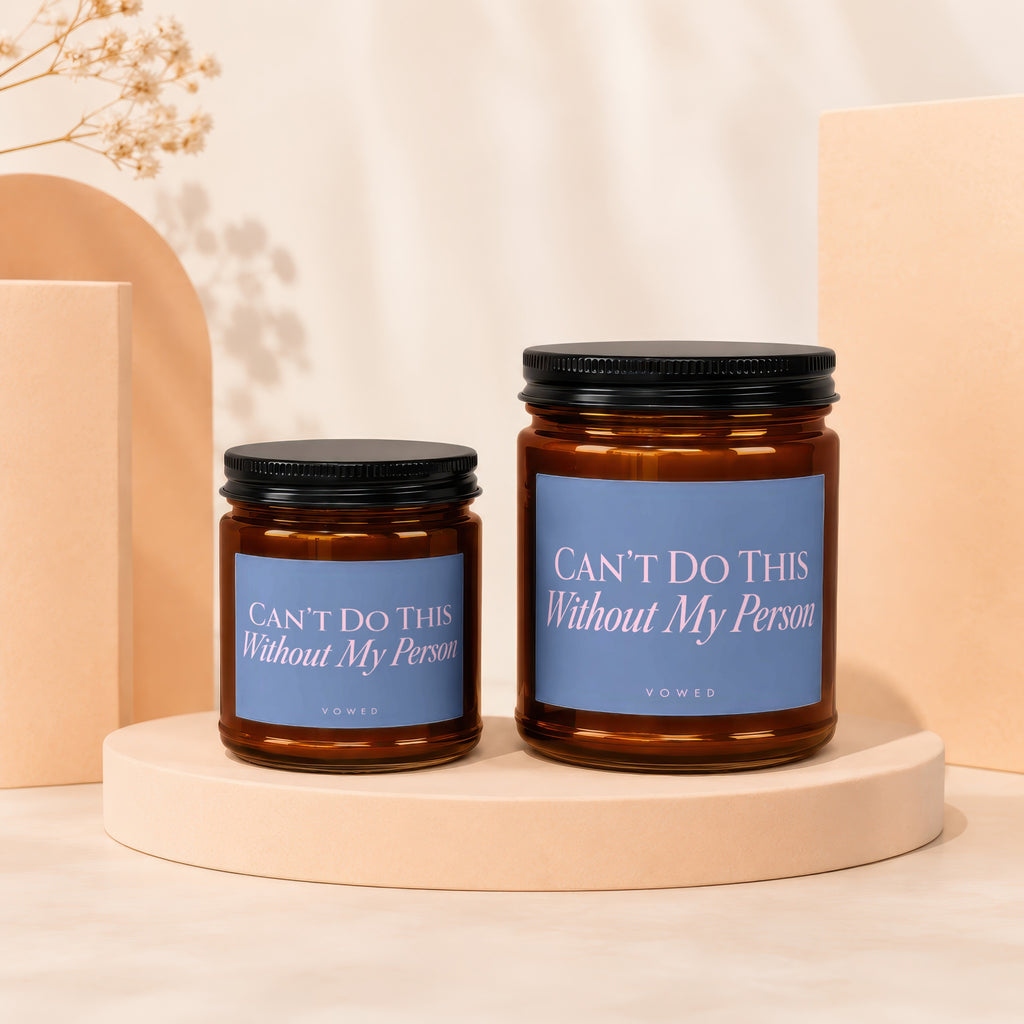 Two brown glass candles with blue labels reading "Can't Do This Without My Person."