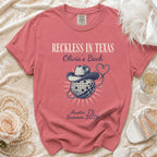 T-shirt with "Reckless in Texas Olivia's Bach Austin, TX Summer 2026" and cowboy hat.