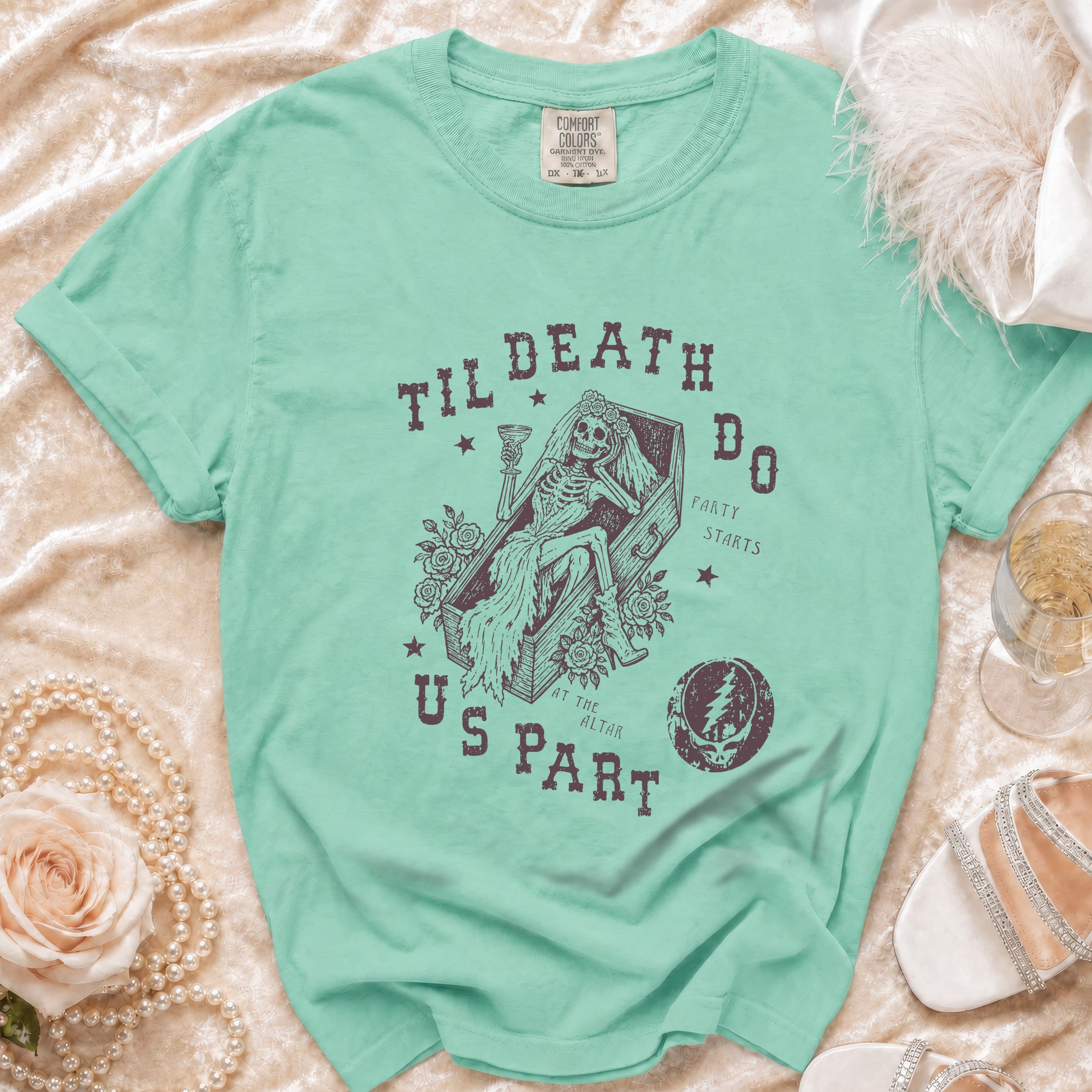 Teal t-shirt with skeleton in coffin graphic, "Til Death Do Party" text.