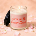 Candle with text "Marrying My Favorite Human" surrounded by pink petals.