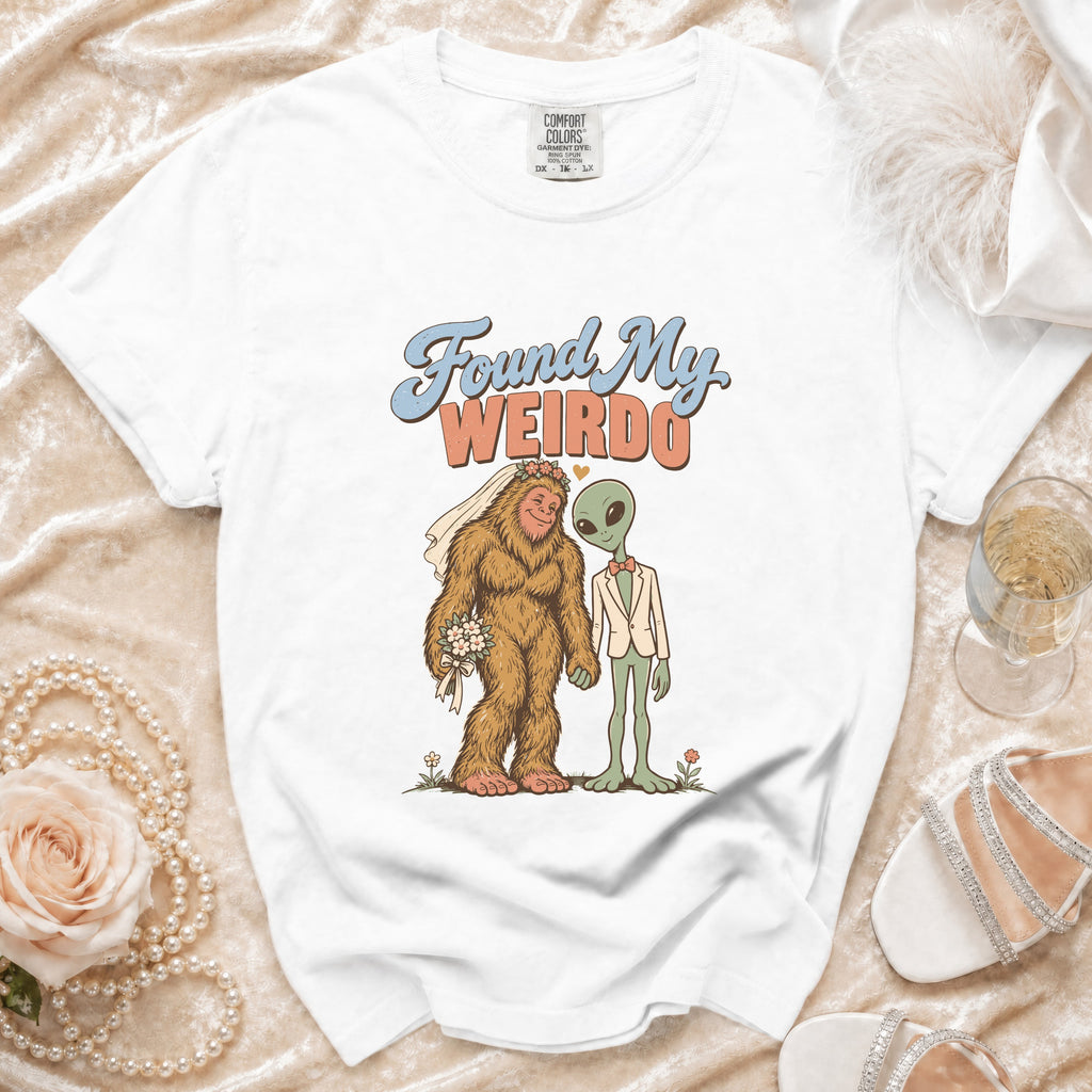 White t-shirt with Bigfoot and alien bride and groom graphic, text reads "Found My Weirdo".