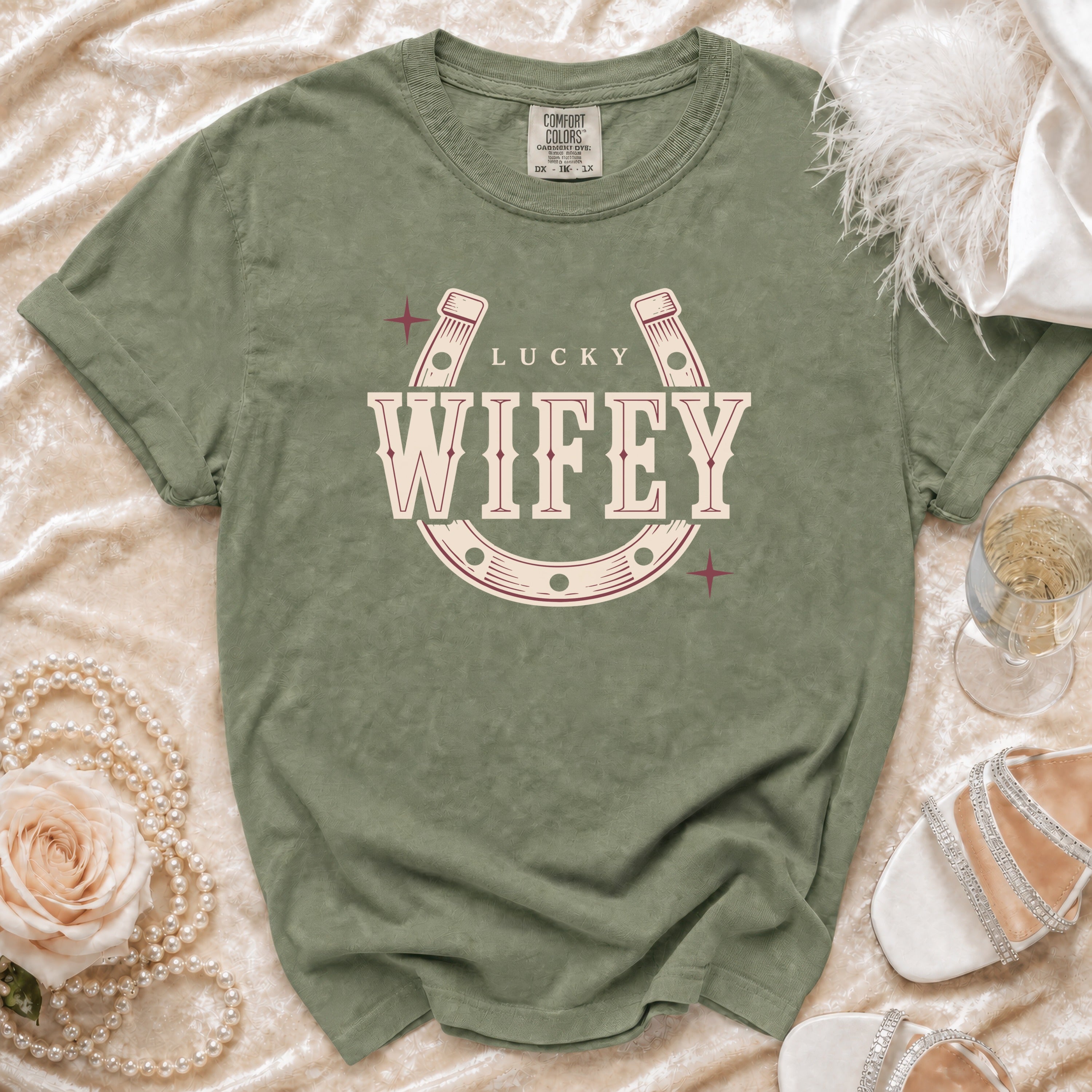Green t-shirt with "Lucky Wifey" text inside a horseshoe graphic.