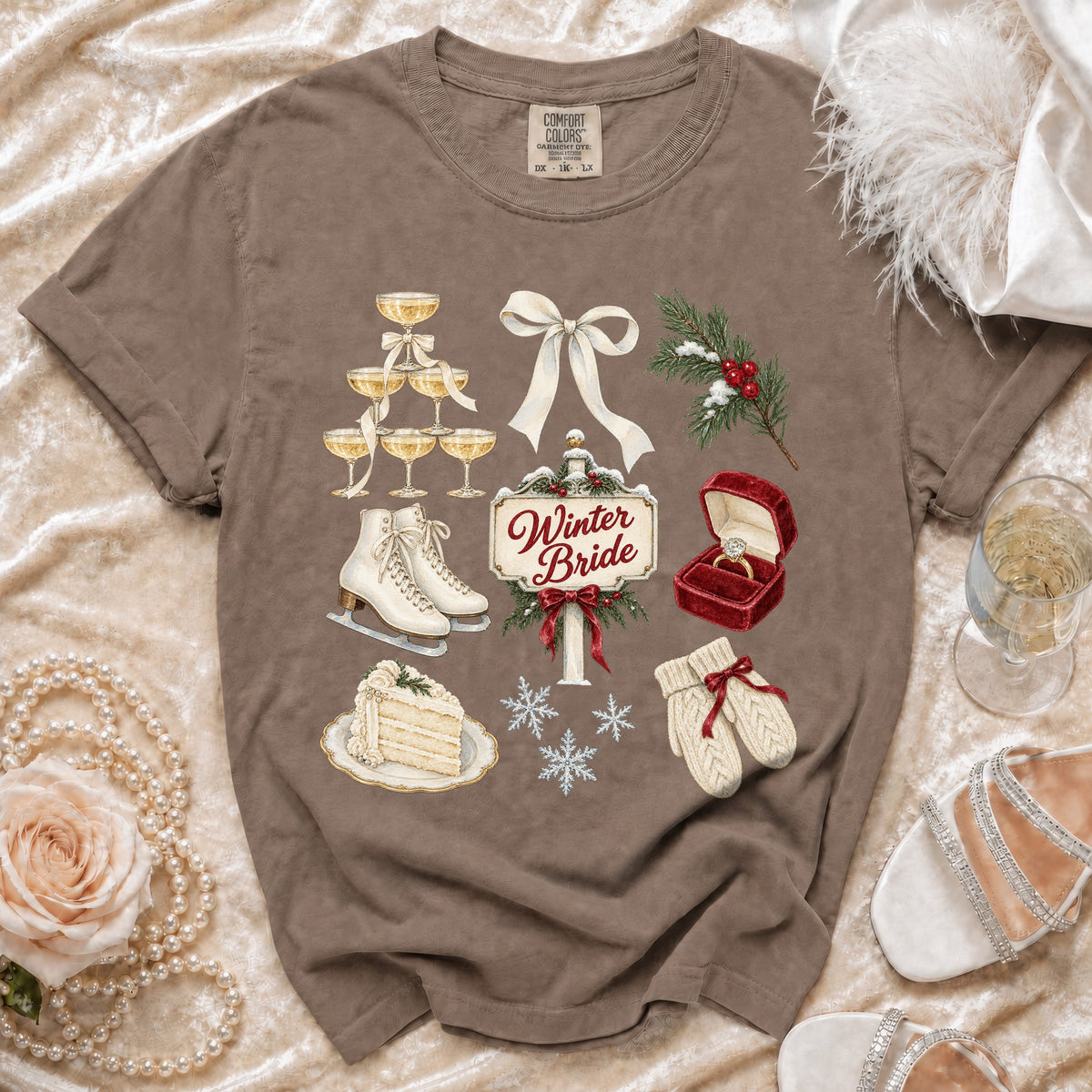 Brown t-shirt with Winter Bride graphic featuring ice skates, champagne, cake, and wedding ring.