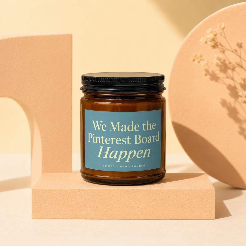 Amber glass candle with blue label reading "We Made the Pinterest Board Happen".