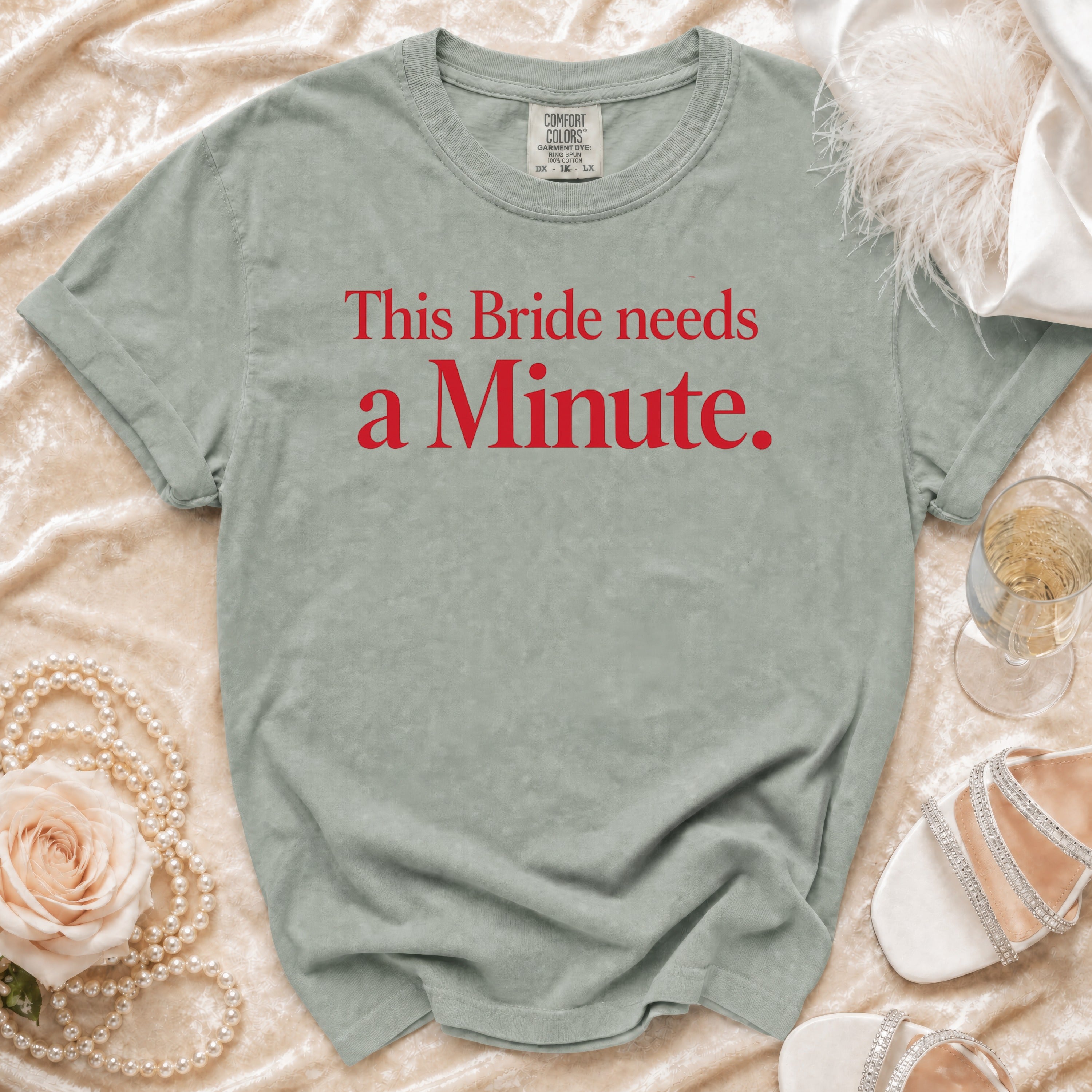 Sage green t-shirt with red text "This Bride needs a Minute".