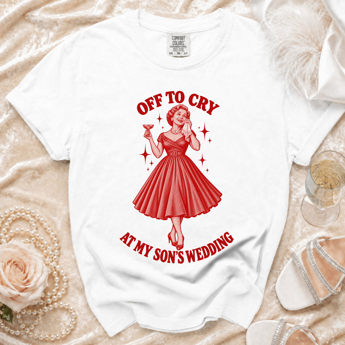 White t-shirt with red graphic of woman crying with martini and text "OFF TO CRY AT MY SON'S WEDDING".