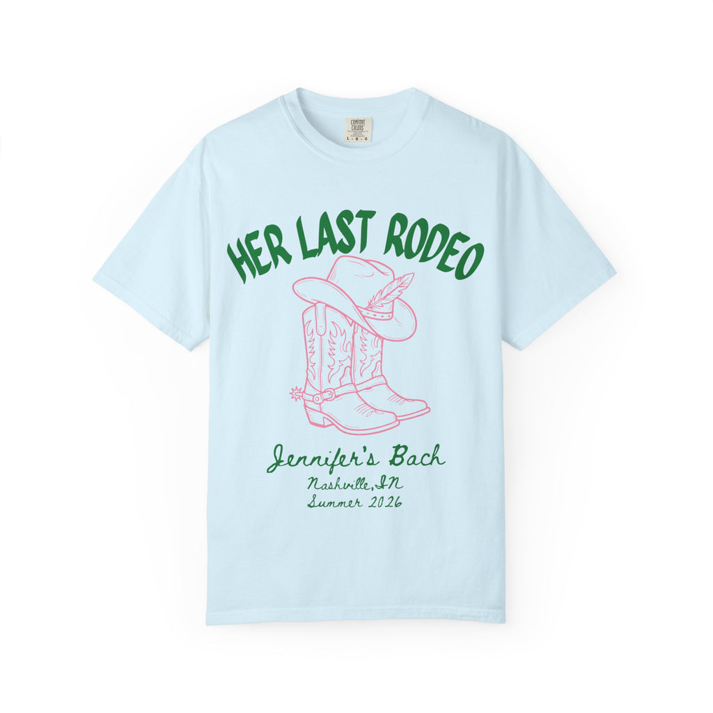 Light blue t-shirt with pink "HER LAST RODEO" text, cowboy boots, and hat.