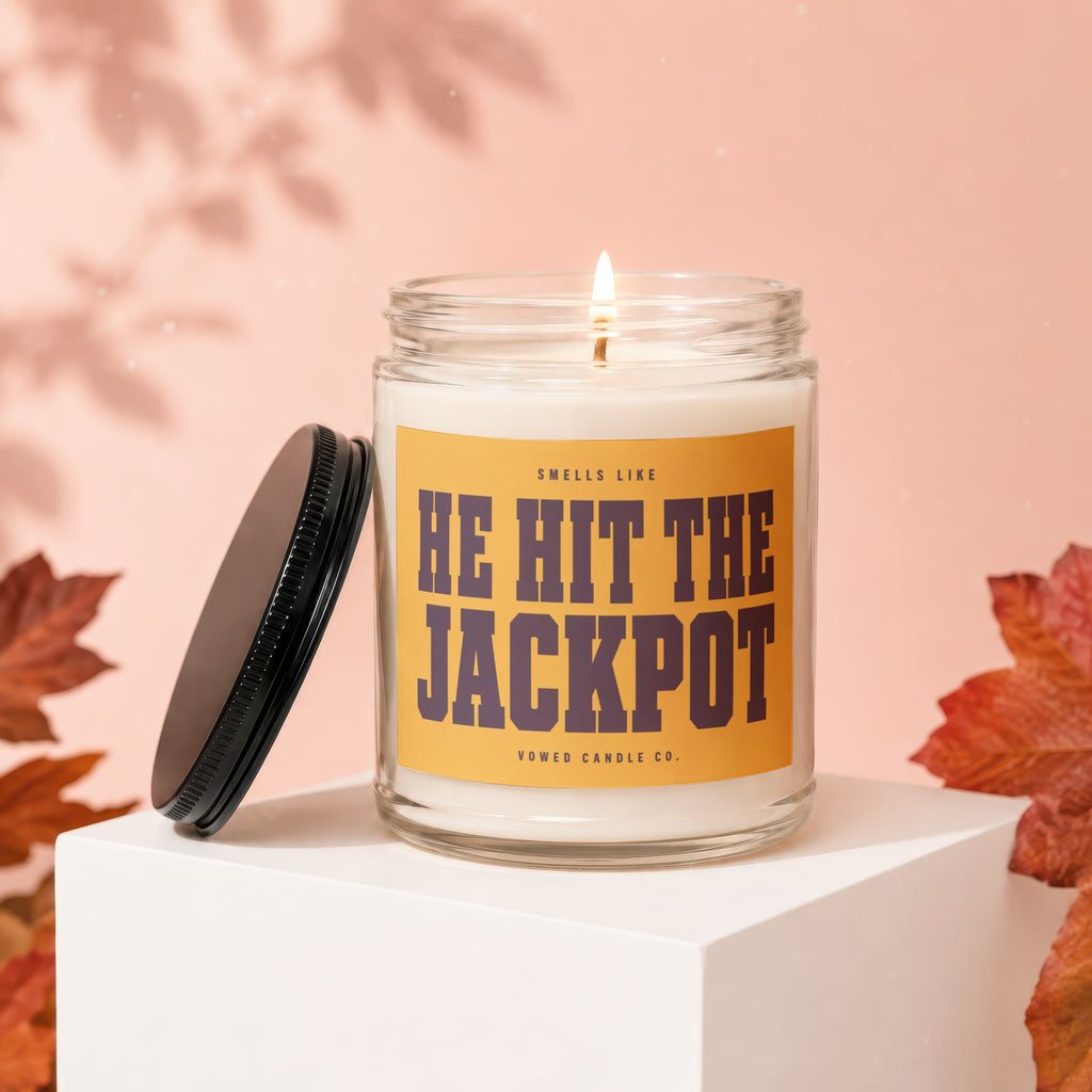 Jar candle with text "HE HIT THE JACKPOT" by Vowed Candle Co.
