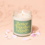 Lit candle in glass jar with green label reading "Better Together Legally VOWED".