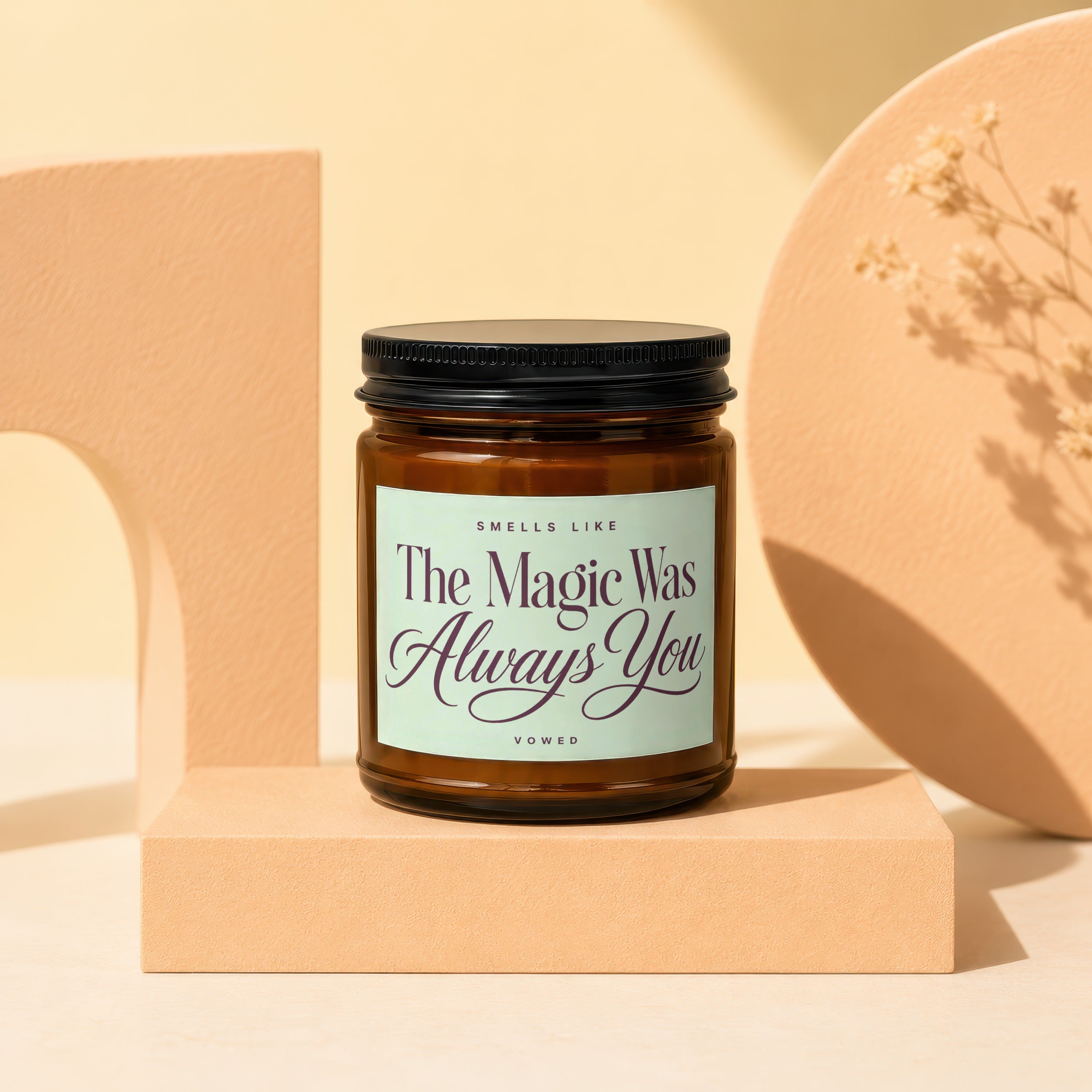 Brown glass candle with black lid, label reads "Smells Like The Magic Was Always You".