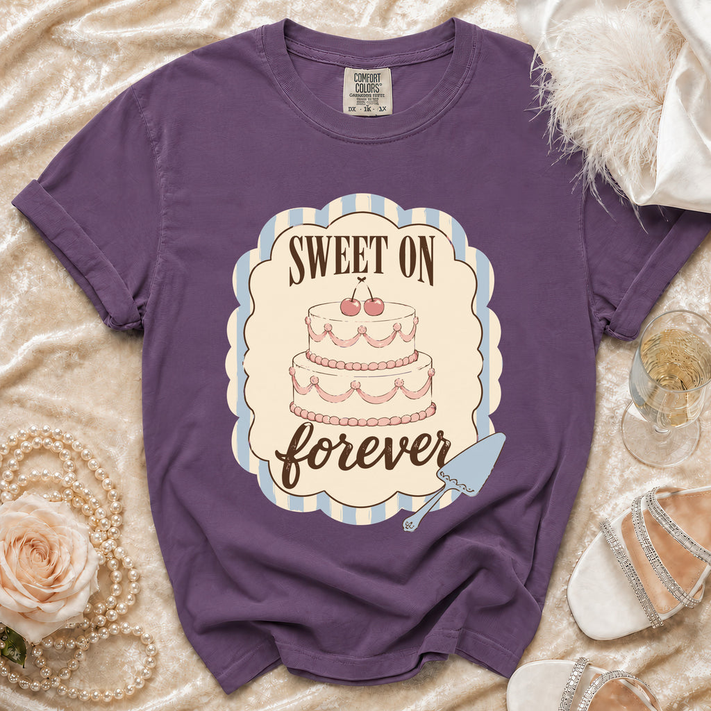 Purple t-shirt with a graphic of a two-tier cake and the words "Sweet On Forever".