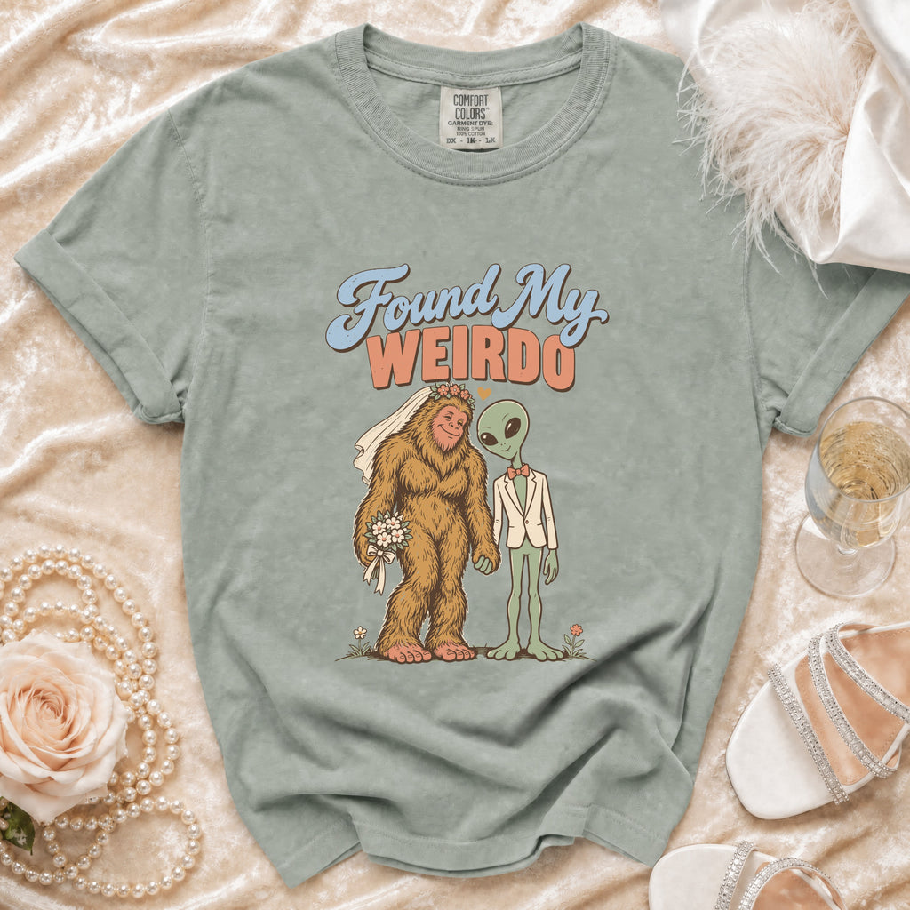Green t-shirt with Bigfoot bride and alien groom graphic saying "Found My Weirdo."