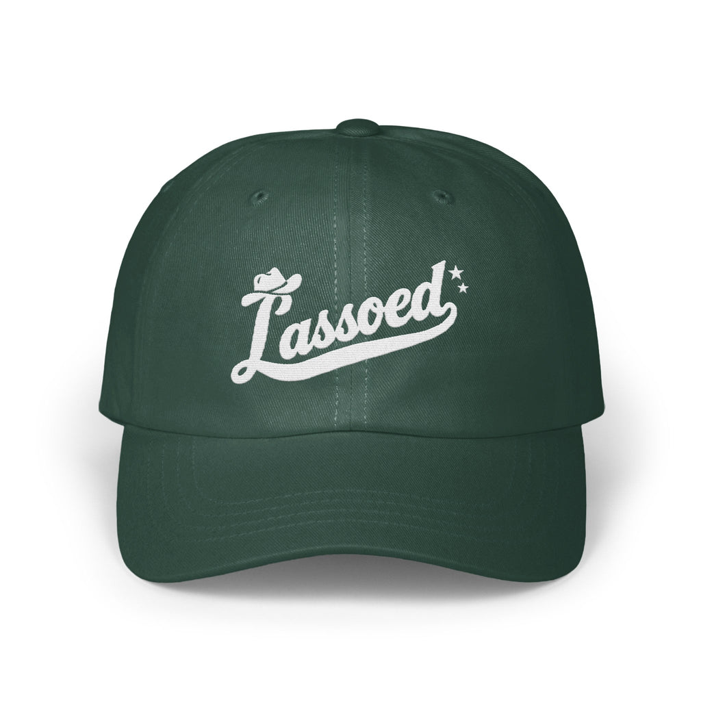 Dark green baseball cap with white embroidered cursive text that reads Lassoed on the front.