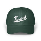 Dark green baseball cap with white embroidered cursive text that reads Lassoed on the front.