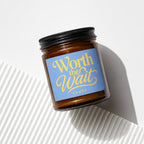 Amber glass candle with a blue label that reads "Worth the Wait" and "vowed".