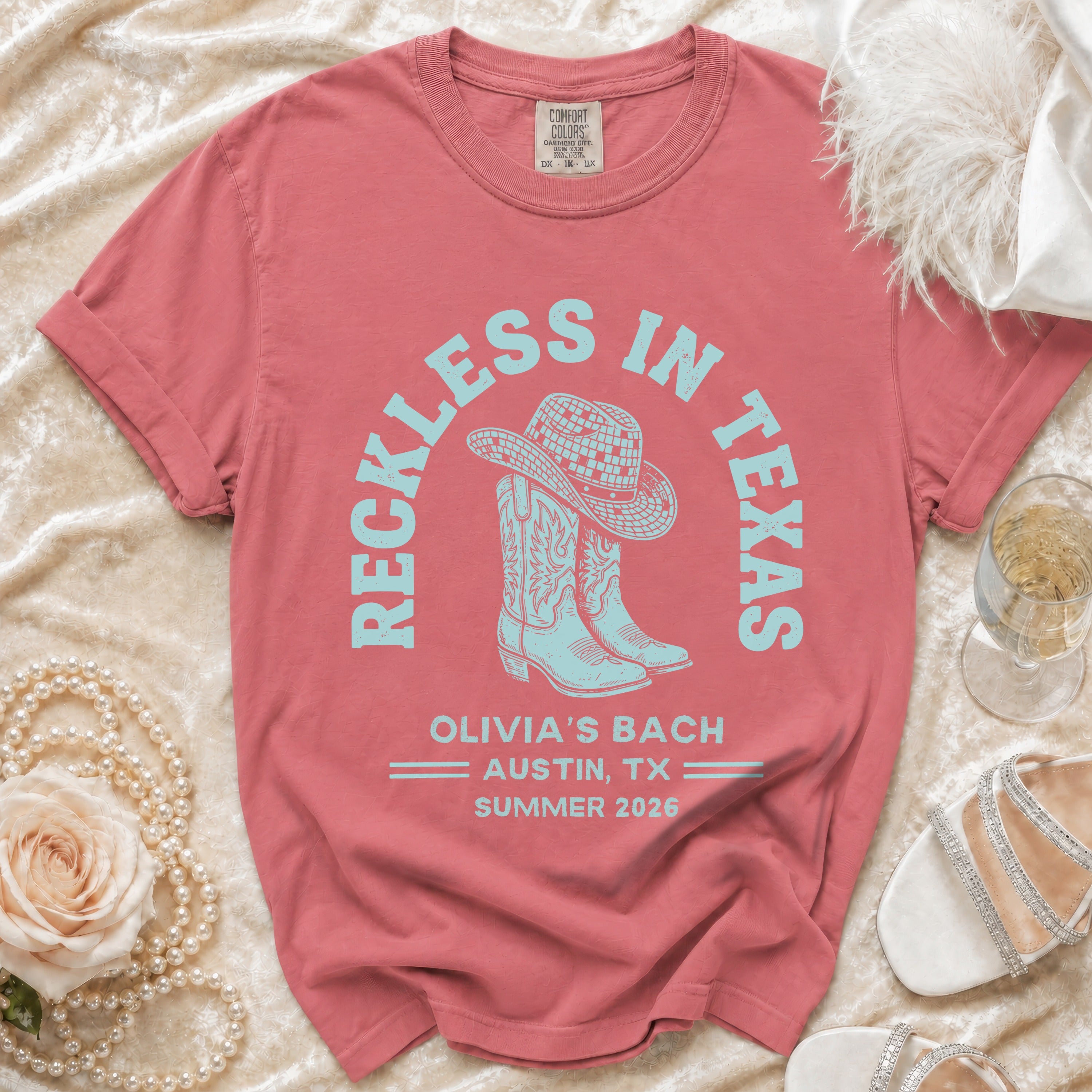 Red t-shirt with "Reckless in Texas" and cowboy boot graphic.