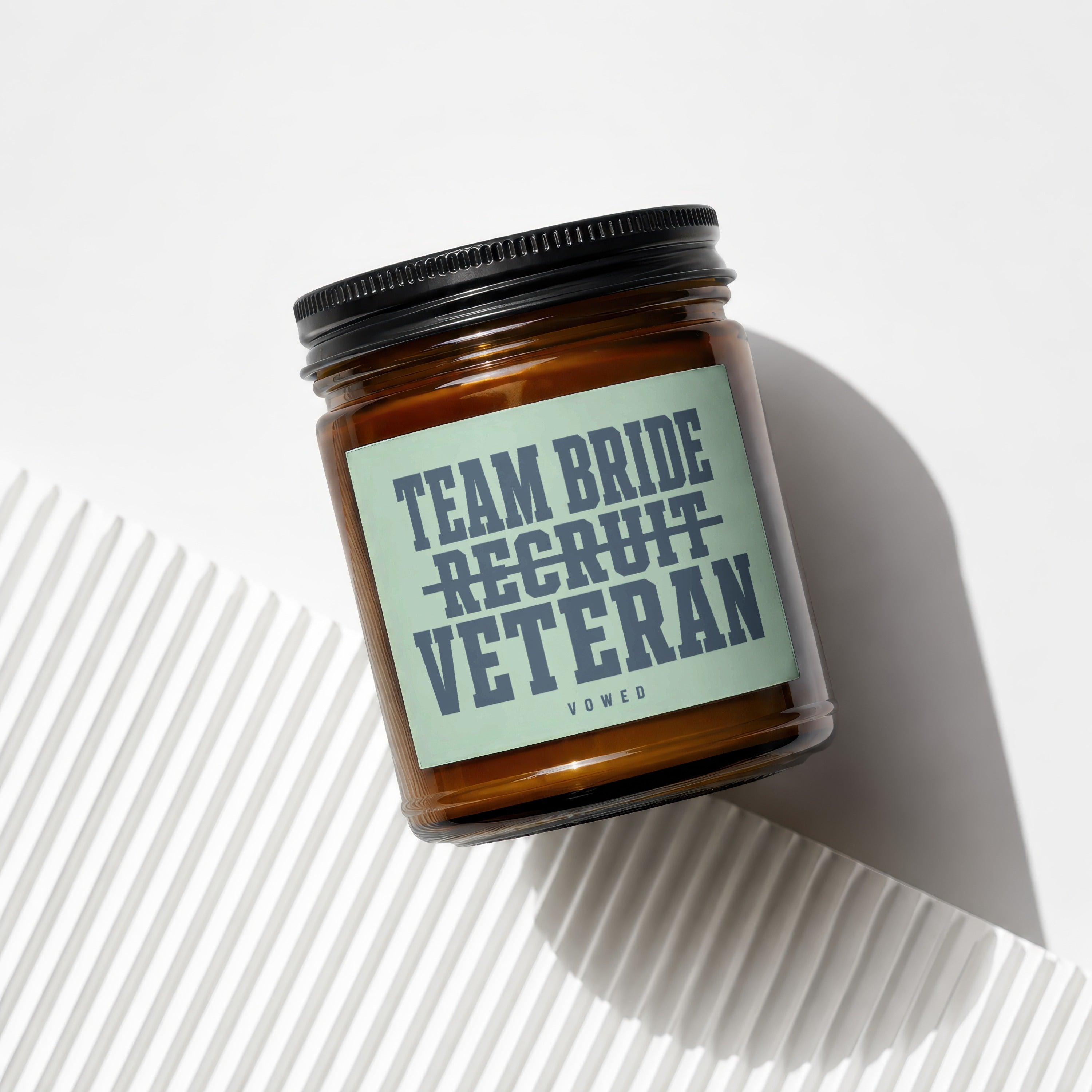 Amber candle with "Team Bride Veteran" text and VOWED logo on label.