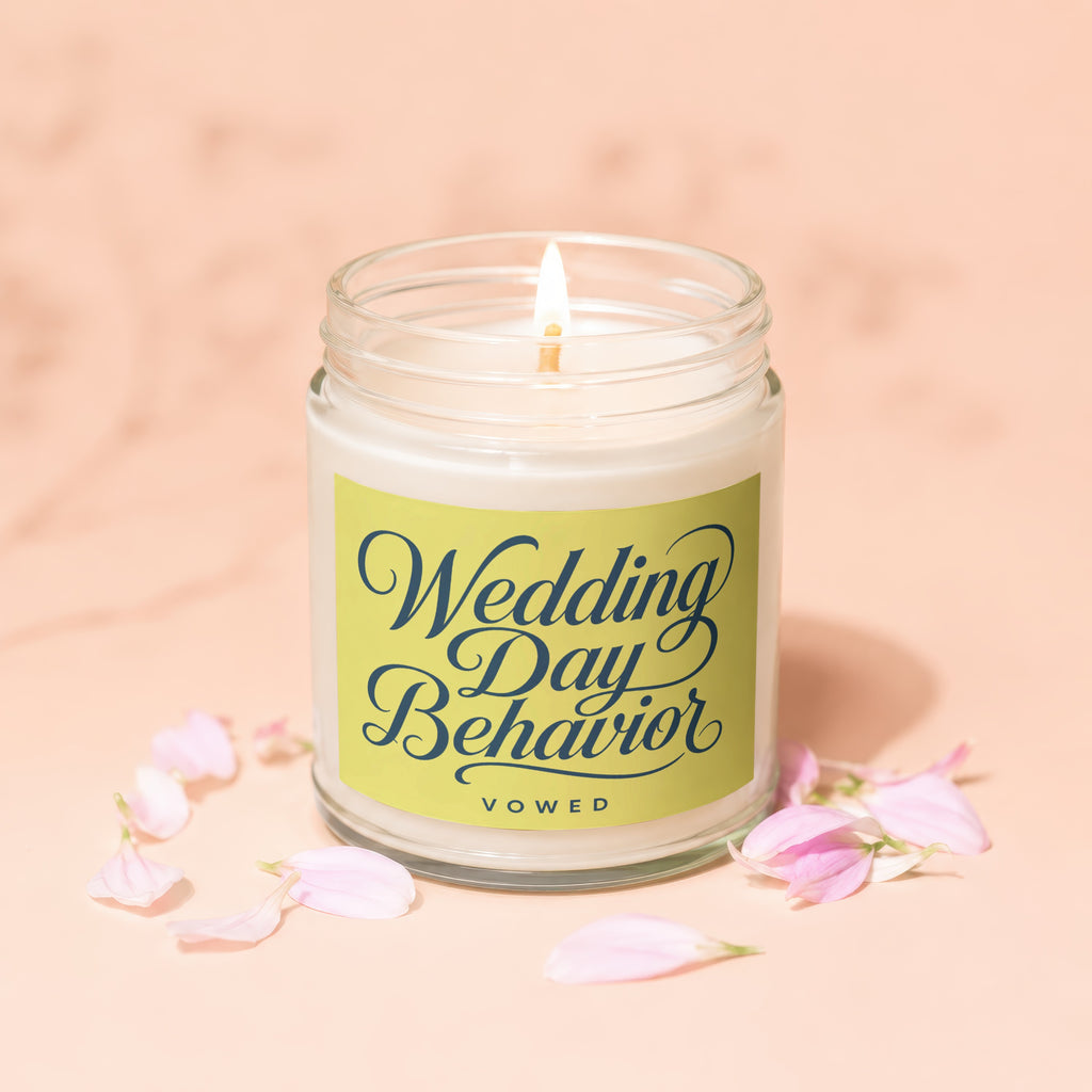 A lit candle with "Wedding Day Behavior VOWED" text on its label.