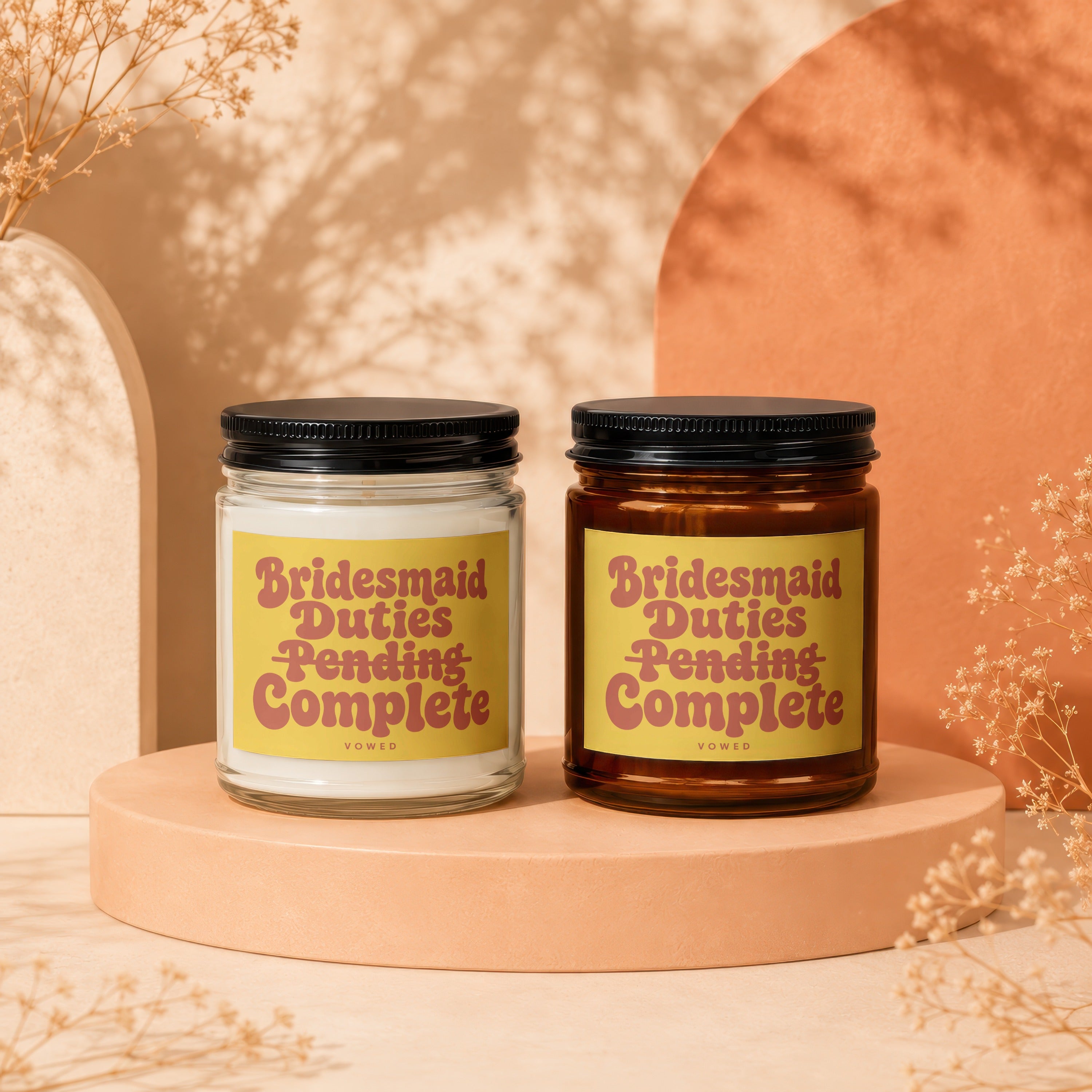 Two candles with yellow labels reading "Bridesmaid Duties Pending Complete".