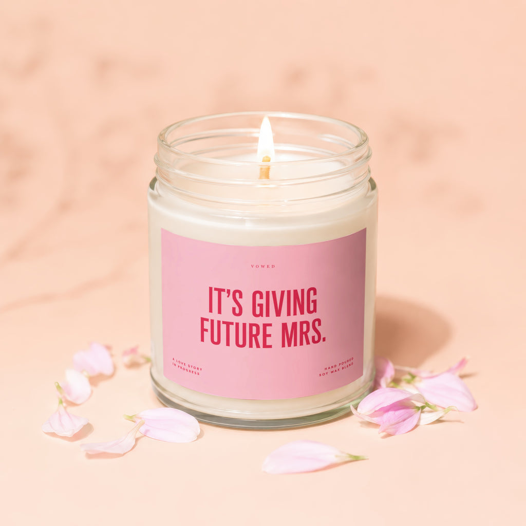 Vowed candle with text "It's Giving Future Mrs." surrounded by petals.