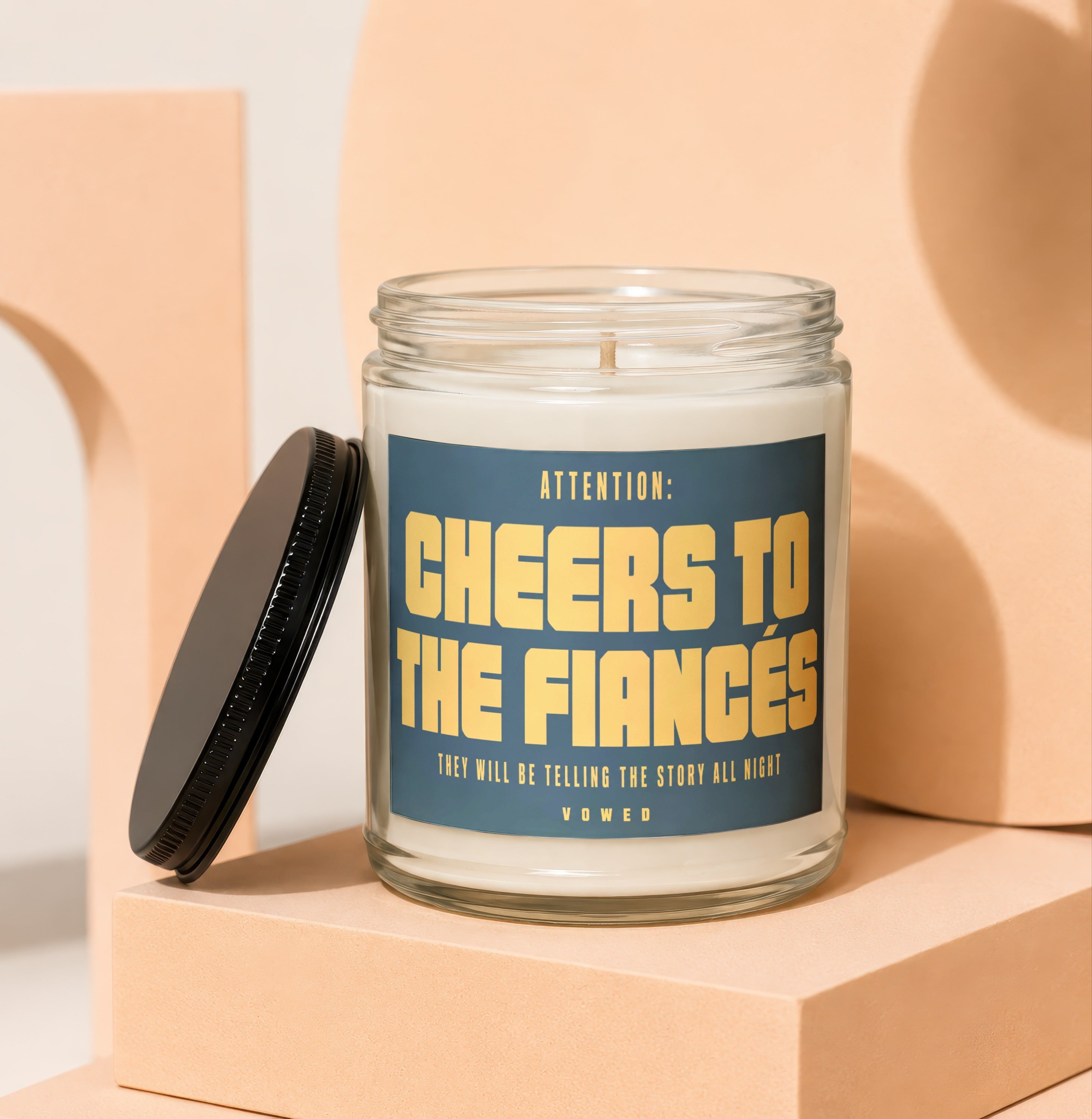 Candle with label "Attention: Cheers to the Fiances Vowed".