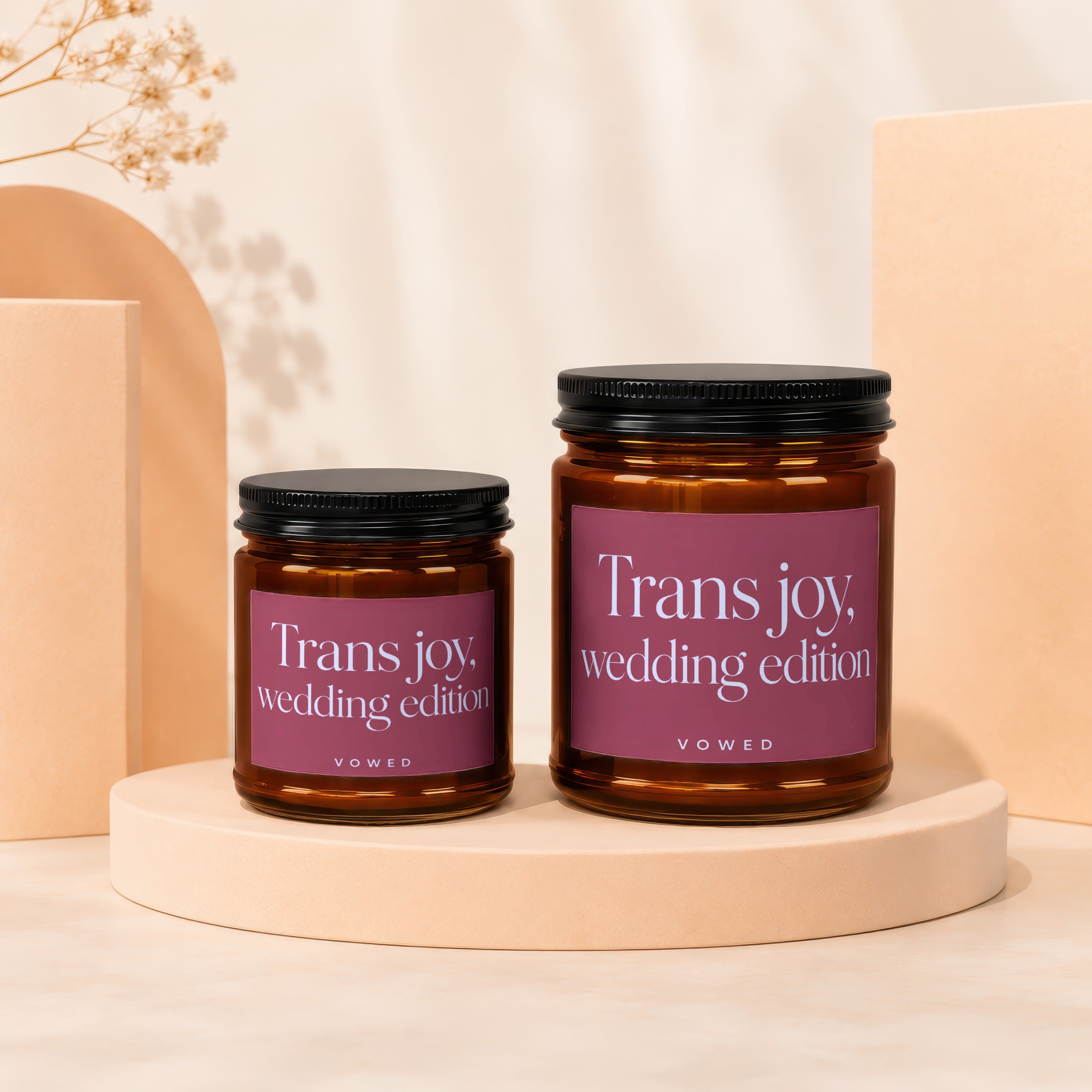 Two amber glass candles with "Trans joy, wedding edition" labels.