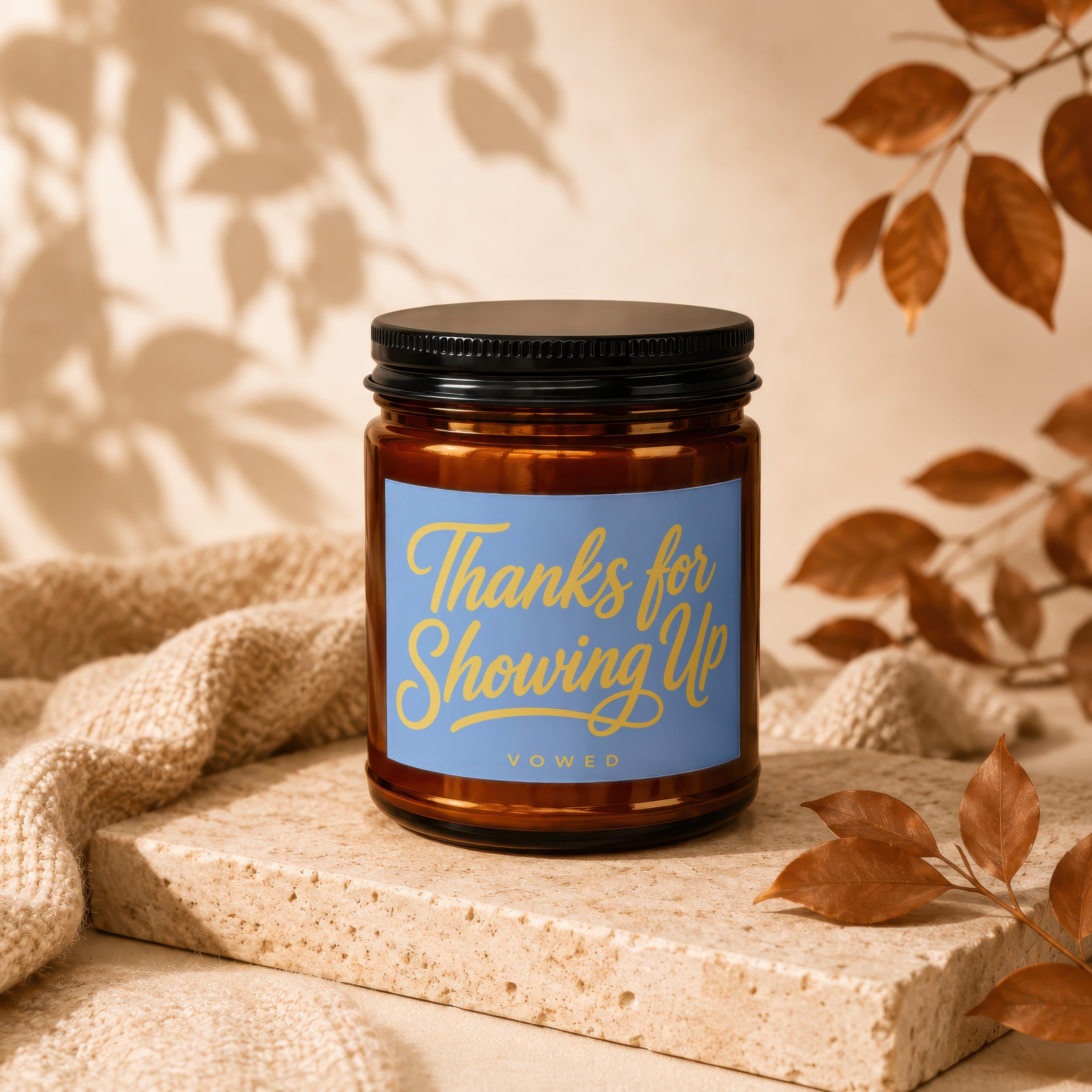 Amber jar candle with blue label reading "Thanks for Showing Up, vowed".