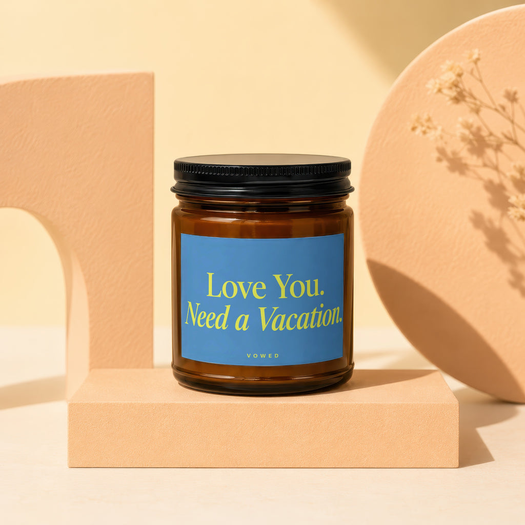 Amber jar candle with blue label that reads "Love You. Need a Vacation."