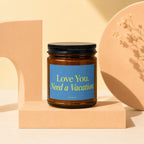 Amber jar candle with blue label that reads "Love You. Need a Vacation."