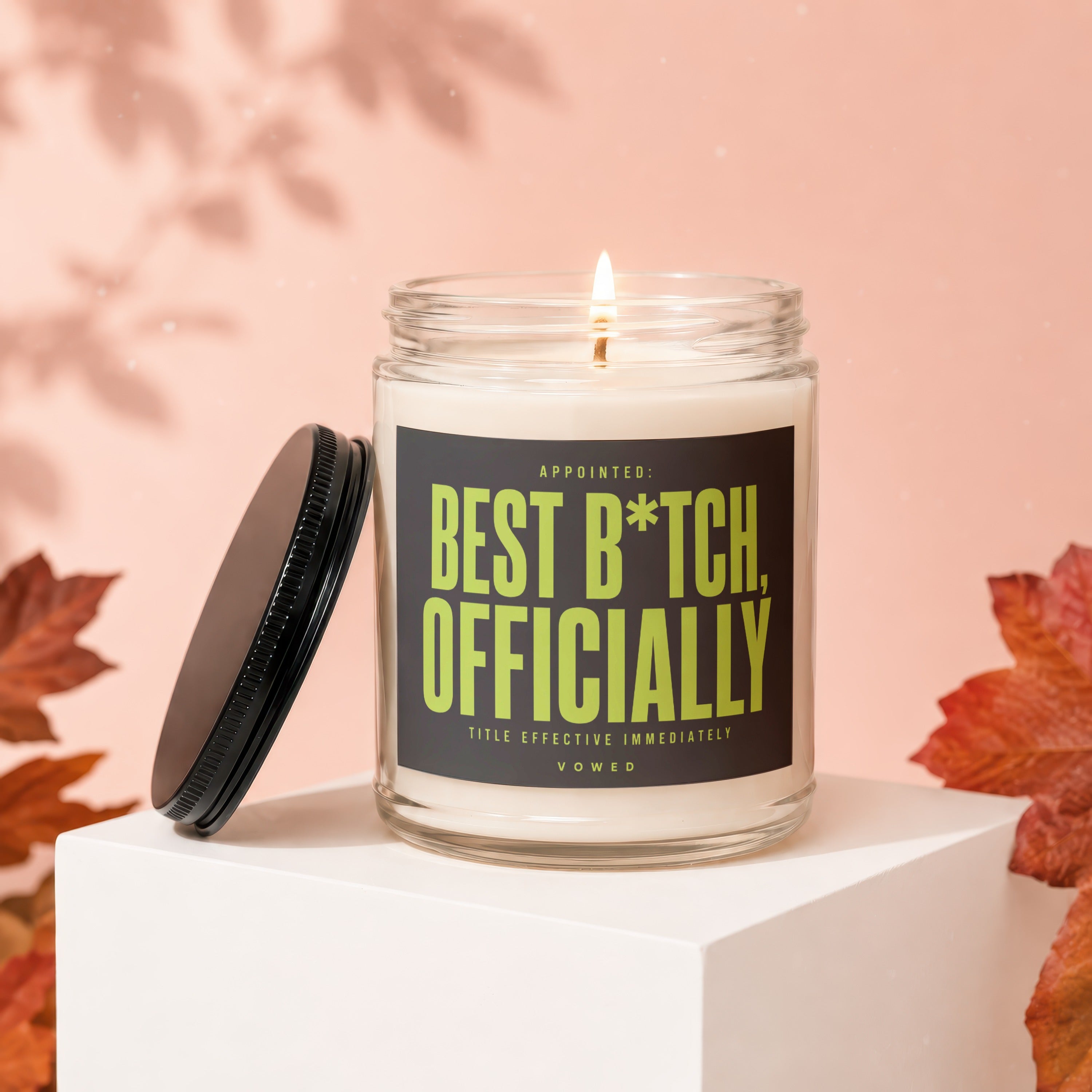 Candle with "Best B*tch, Officially Vowed" text on label, lid removed.