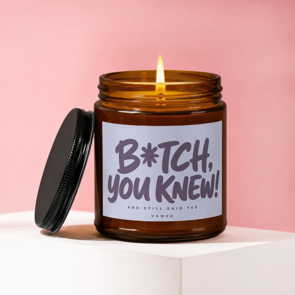 Amber jar candle with lit wick and text "B*tch, you knew! And still said yes Vowed."