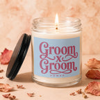 Candle with "Groom x Groom VOWED" text on a light blue label.