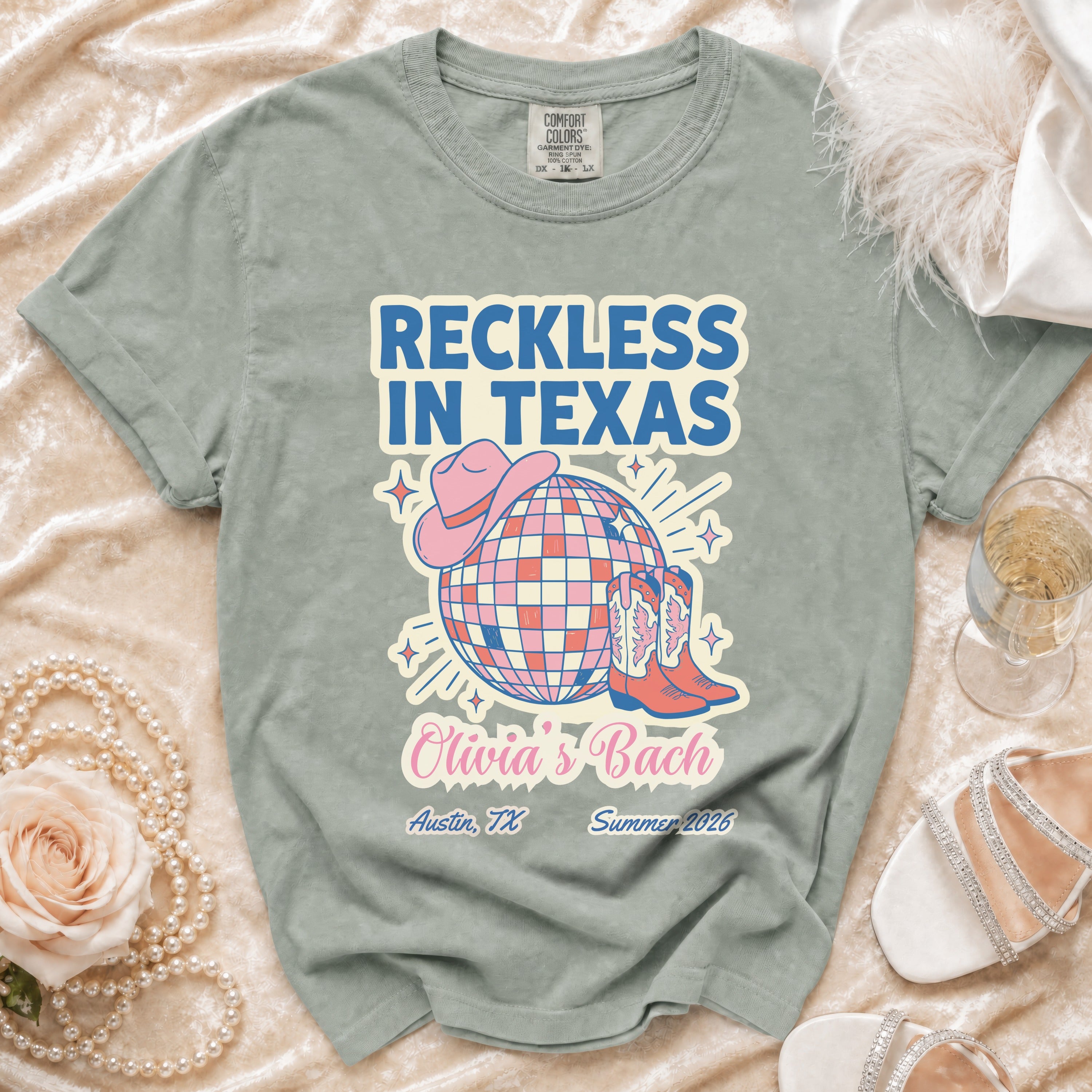 Reckless in Texas t-shirt with disco ball, cowboy boots, and pink hat.