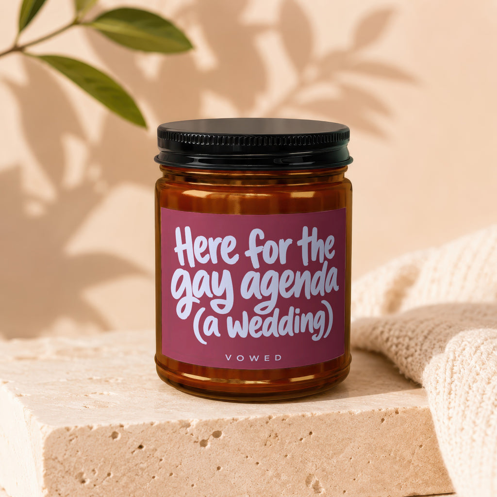 Amber jar candle with label text "Here for the gay agenda (a wedding)".